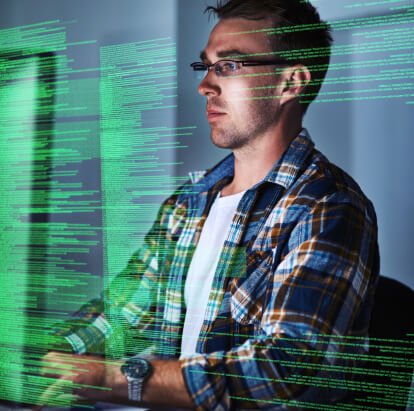 A man focused on his work at a computer screen, engaged in a task.